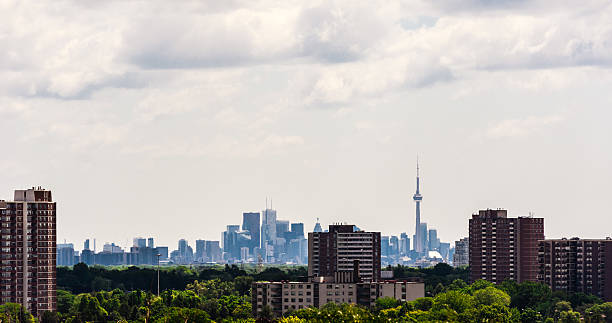 Suburban apartment buildings against dense Toronto downtown. Toronto, Canada - July 10, 2016: Older apartment buildings stand among trees in suburban Etobicoke, with dense downtown Toronto in the distance. etobicoke stock pictures, royalty-free photos & images