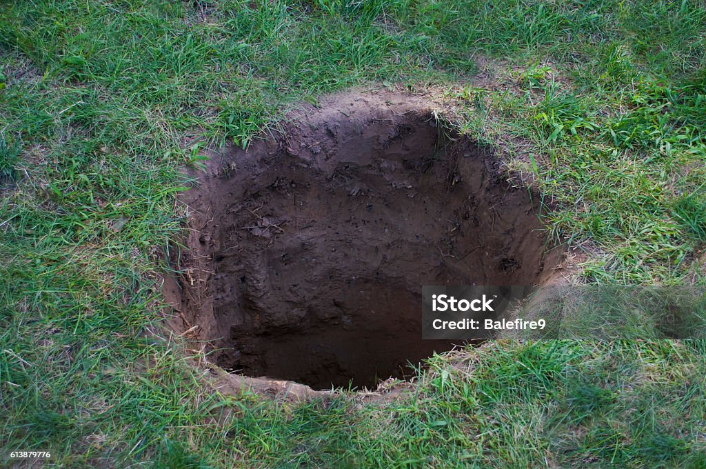 Deep dirt hole in ground or lawn Hole Stock Photo
