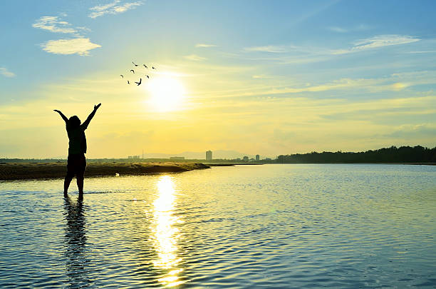 istock Silhouette of Man Raising His Hands  when sunset 613880118