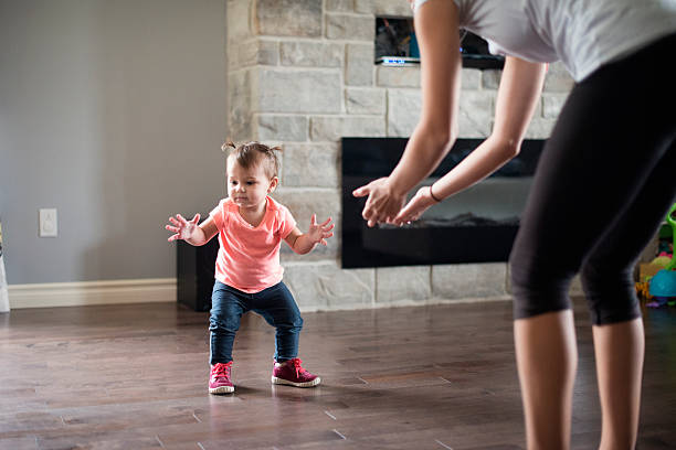 istock Baby girl's first step with her mother 613882818