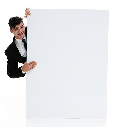 Portrait of young male dressed in a black chef suit doing I am watching you gesture posing on a black isolated background with copy space advertising area