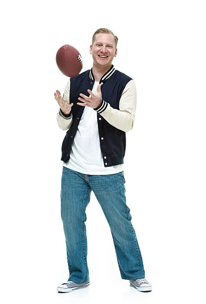 istock Smiling student holding American football 613886428