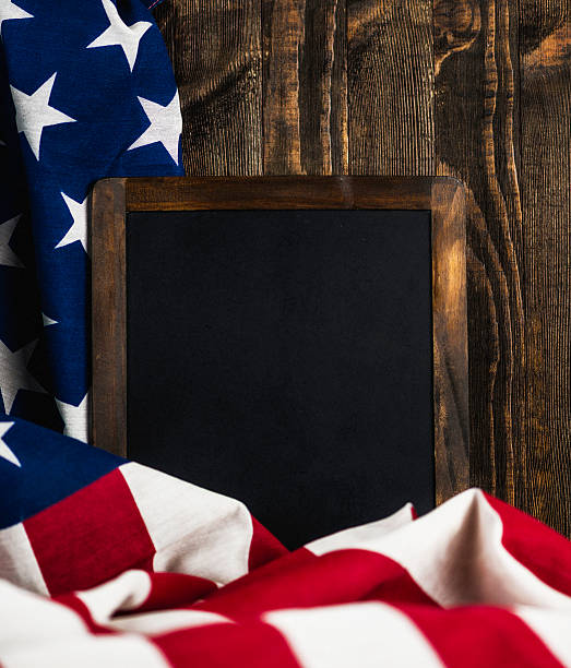 istock American flag with blank chalkboard for US holidays. Wood background 613886830