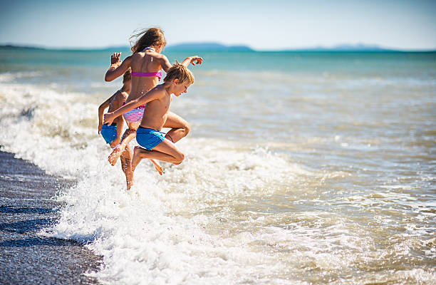 istock Summer vacations - kids jumping into sea 613888222