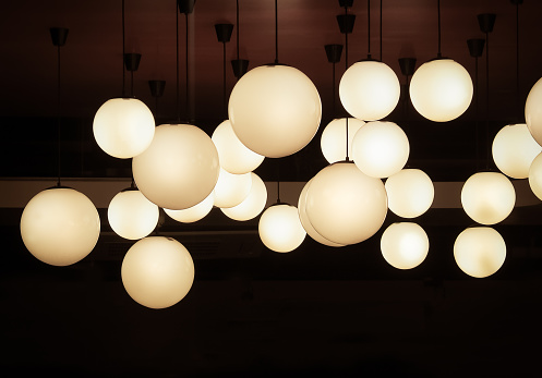 Lighting ball hanging from the ceiling on the black background