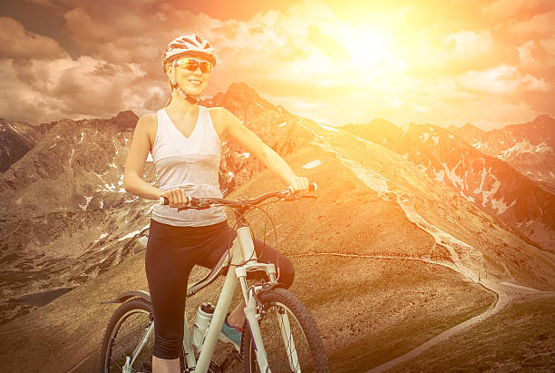 istock Woman stay on the bicycle around mountains 613889156