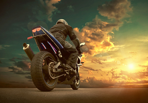 Hombre asiento en la motocicleta bajo cielo con nubes photo