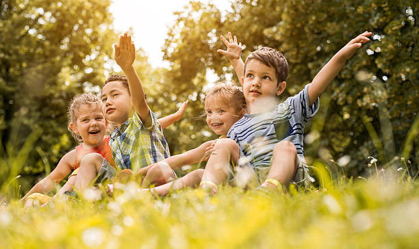 istock Happy little kids having fun while relaxing in grass. 613889918