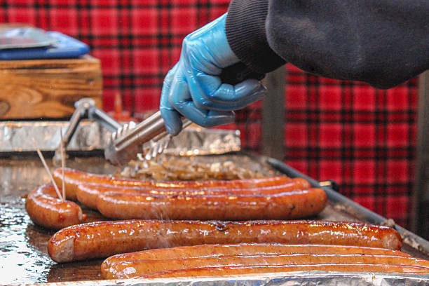 istock Close up chef hands cooking sausages 613890424