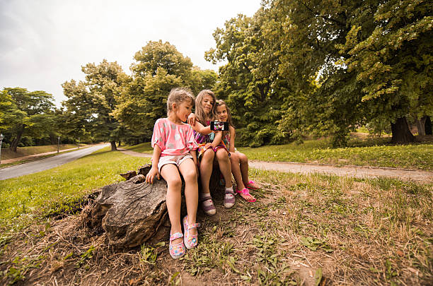 istock Small girls having fun while taking a selfie in nature. 613891684