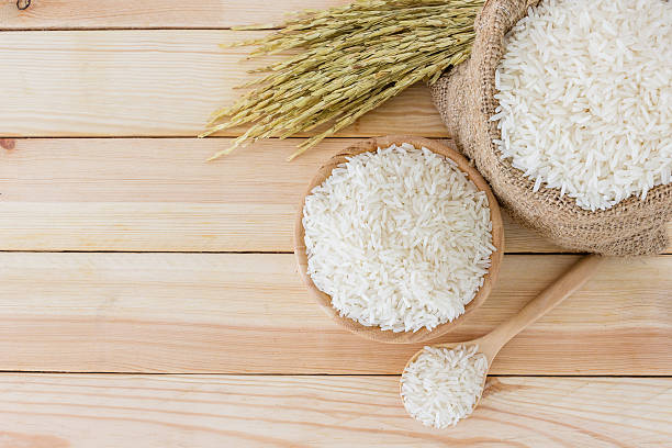 istock White rice in bowl and a bag on a wooden table. 613894752