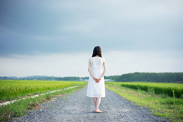 istock Woman standing in a rice paddy 613895230