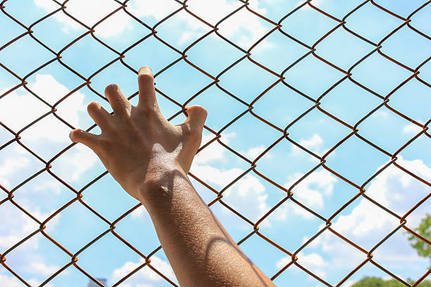 istock Hands holding fence on outdoor scenery during daylight 613895234