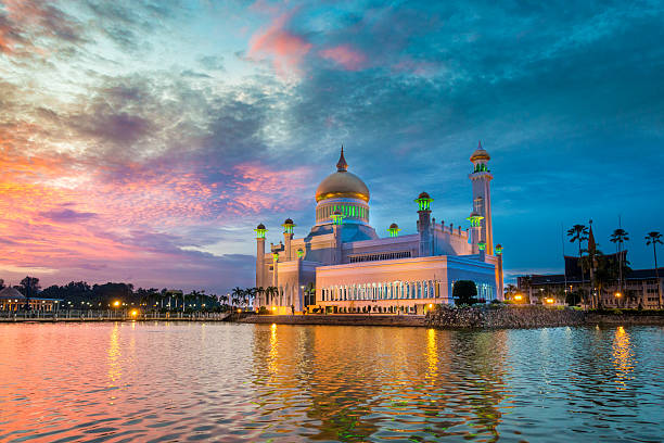 mosquée sultan omar ali saifuddin, brunei au crépuscule - bandar seri begawan photos et images de collection