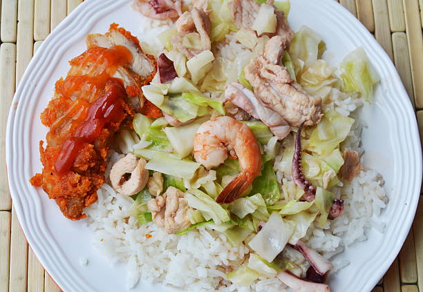istock stir fried cabbage with seafood and crispy chicken on rice 613899244