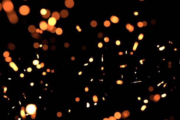 istock blurred sparks from fire in front of black backgound 613899804