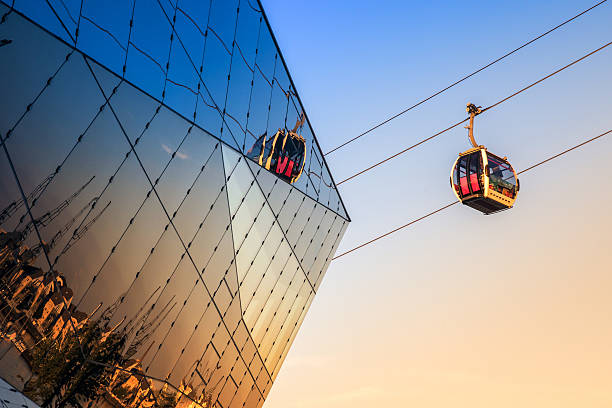 Thames Cable Car in London Thames cable car seen through The Crystal building at Royal Victoria Dock in London at sunset overhead cable car photos stock pictures, royalty-free photos & images