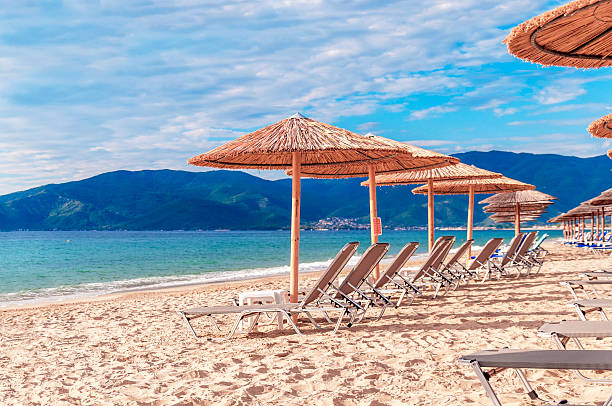 istock Gray straw umbrella on beautiful beach and ocean and sky 613900588
