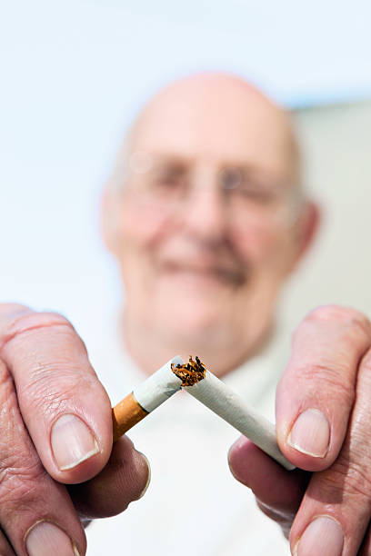 istock Give up smoking; it's never too late! Senior snaps cigarette. 613901630