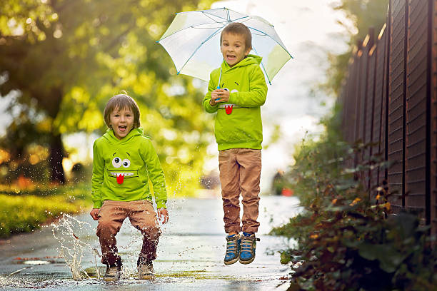 istock Two adorable little boys, playing in park on rainy day 613902244