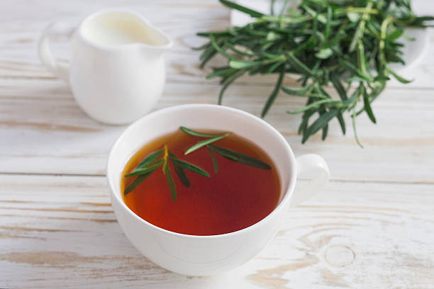 istock Rosemary tea and milk jar on wooden table. 613907004