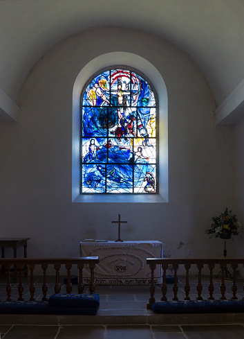 Tudeley, England - June 16, 2015: The nave and altar of the All Saints Church with a stained glass window designed by Marc Chagall.