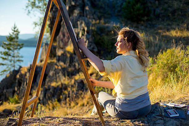 istock young artist draws a seascape at sunset 613907160