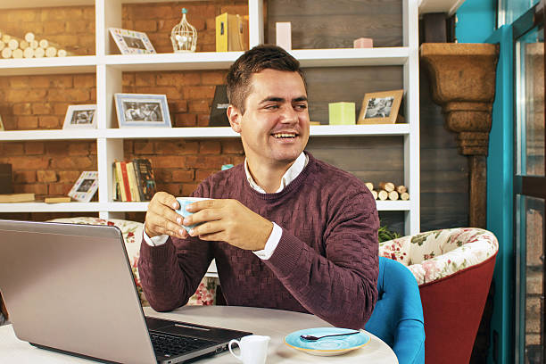 istock Happy young man smiling and works on his laptop 614011660