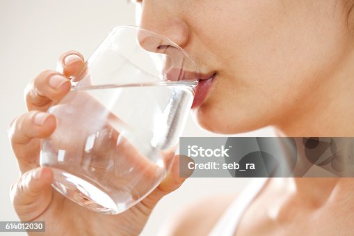 istock Young woman drinking  glass of water 614012030