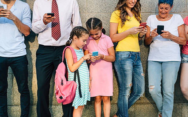 istock Little girls texting among adults 614012556