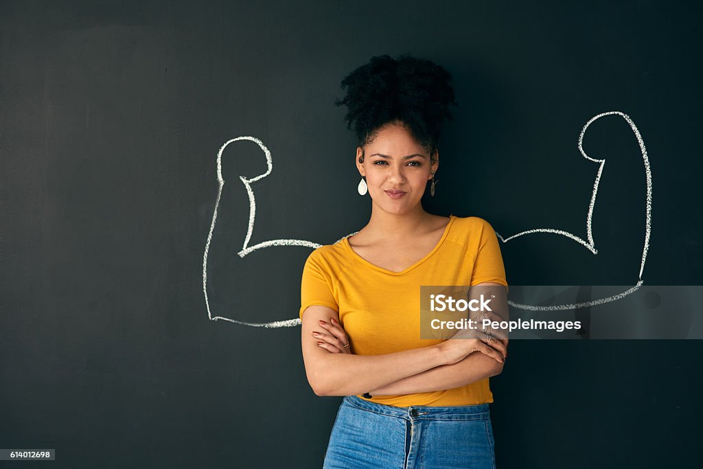 I am a strong woman! Shot of a woman posing with a chalk illustration of flexing muscles against a dark background Strength Stock Photo