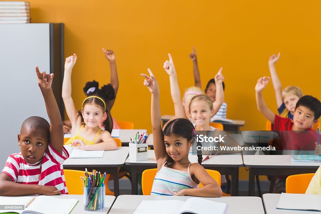 Les écoliers lèvent la main en classe - Photo de Lever la main libre de droits