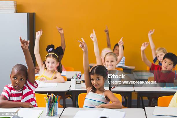 Photo libre de droit de Les Écoliers Lèvent La Main En Classe banque d'images et plus d'images libres de droit de Lever la main - Lever la main, Niveau d'éducation, Enfant