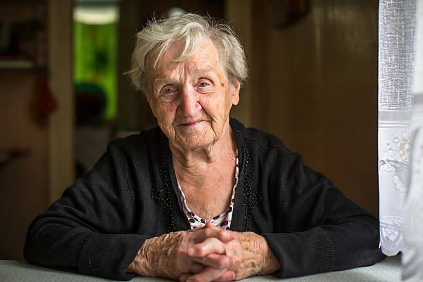 istock An elderly woman sitting at the table, portrait. 614014434