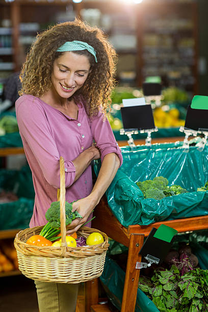 istock Smiling woman buying vegetables in organic section 614014468