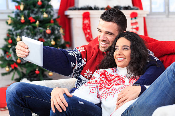 istock Young couple embracing and making selfie at home 614014612