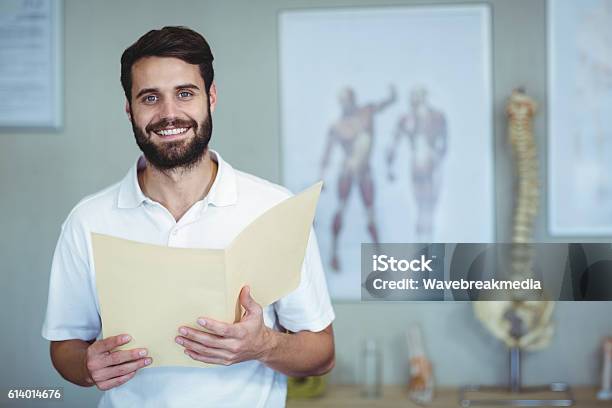 Portrait Of Physiotherapist Holding File Stock Photo - Download Image Now - Osteopath, Physical Therapy, Doctor