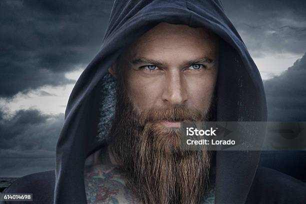 Hooded Bearded Tattooed Male In Fantasy Cloudy Seascape Setting-foton och fler bilder på Män