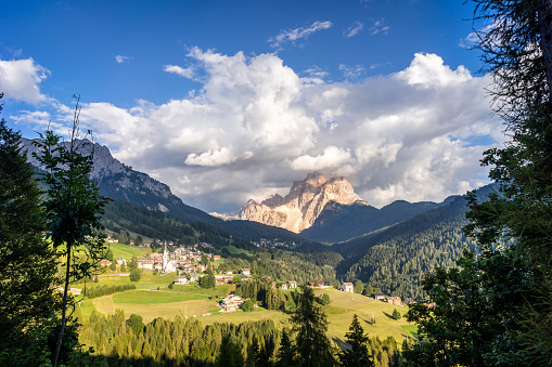 Typical summer scene in Italian Dolomites. Traditional mountain villages with majestic mountains in background.