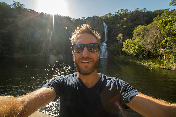 handsome young man traveling takes selfie portrait - wangi falls imagens e fotografias de stock
