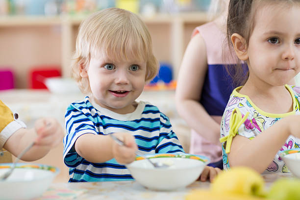 istock children eating from plates in day care centre 614017632
