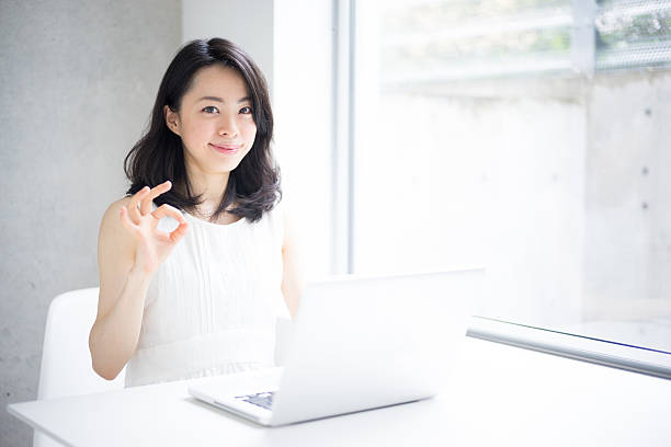 istock Woman using a laptop and making ok sign 614017934