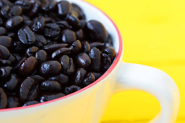 istock coffee bean in coffee cup with yellow background. 614020636