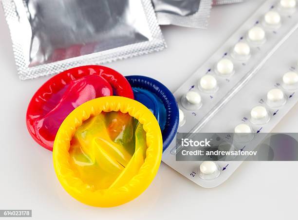 Birth Control Pills And Condoms On White Background Stock Photo - Download Image Now