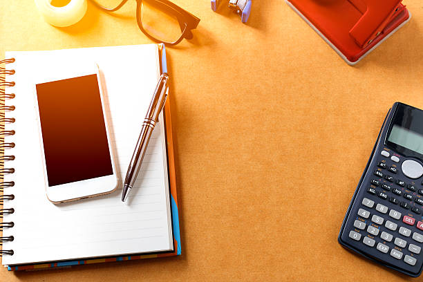 istock Overhead of office table with notebook, pen, mobile phone , calc 614023752