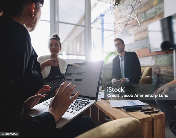 Businesswoman Discussing Business Strategy With Colleagues Stock Photo - Download Image Now