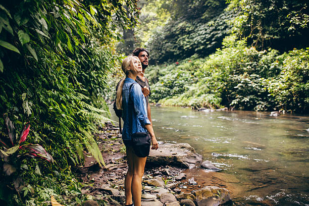 istock Couple standing by stream in woods 614026784