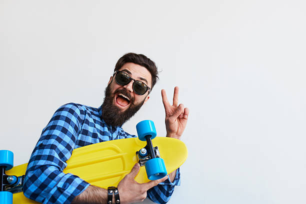 istock Portrait of a smiling hipster guy standing over white wall 614027880
