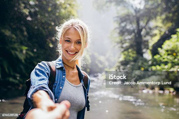 Pareja Joven En Caminata Por La Naturaleza Foto de stock y más banco de imágenes de Mujeres - Mujeres, Agarrados de la mano, Excursionismo