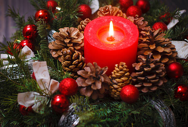 istock Red candle in a wreath of pine branches 614028302